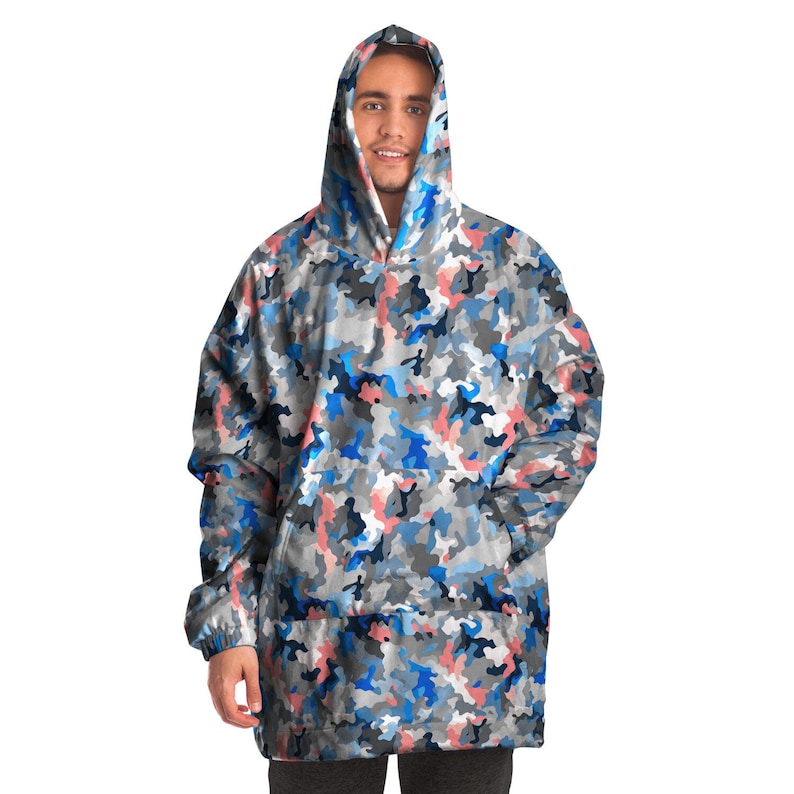 Puede incluir: Una sudadera con capucha de gran tama&ntilde;o con un bolsillo canguro, con estampado de camuflaje azul, rosa y gris.