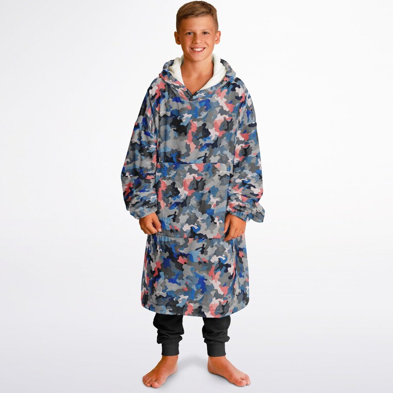 Puede incluir: Una sudadera con capucha de gran tama&ntilde;o con estampado de camuflaje azul, gris y rosa. Tiene un forro de sherpa blanco, un bolsillo grande en la parte delantera y una capucha con cord&oacute;n.