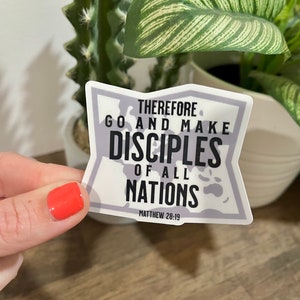 May include: White sticker with a gray outline in the shape of a star. The sticker has black text that reads "Therefore go and make disciples of all nations. Matthew 28:19"