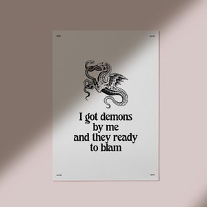 May include: Black and white print of a dragon with the text "I got demons by me and they ready to blame".