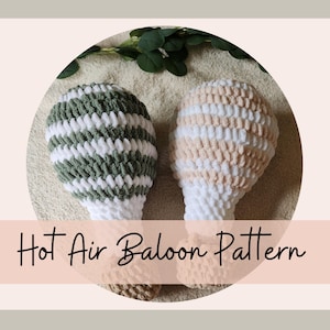 Puede incluir: Dos globos aerostáticos hechos a mano con ganchillo. Uno es de rayas verdes y blancas, el otro de rayas beige y blancas. El texto "Hot Air Balloon Pattern" se muestra en una pancarta rosa.