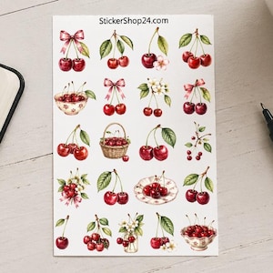 Könnte beinhalten: Ein Bogen mit Kirschaufklebern mit verschiedenen Designs, darunter Kirschen mit Schleifen, in Körben und auf Tellern. Die Aufkleber befinden sich auf weißem Hintergrund mit dem Text "StickerShop24.com". Eine Tasse Kaffee, ein Stift und ein Notizbuch sind ebenfalls vorhanden.