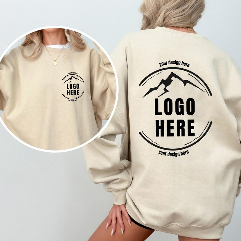 May include: A beige sweatshirt with a black circle logo on the back that says "LOGO HERE" and "your design here" above and below the logo. The front of the sweatshirt has a smaller version of the logo.