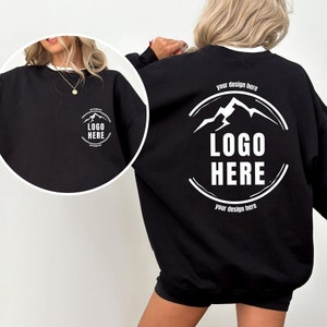 May include: Black sweatshirt with a white mountain graphic and the text "LOGO HERE" in a circle. The text "your design here" appears above and below the circle.