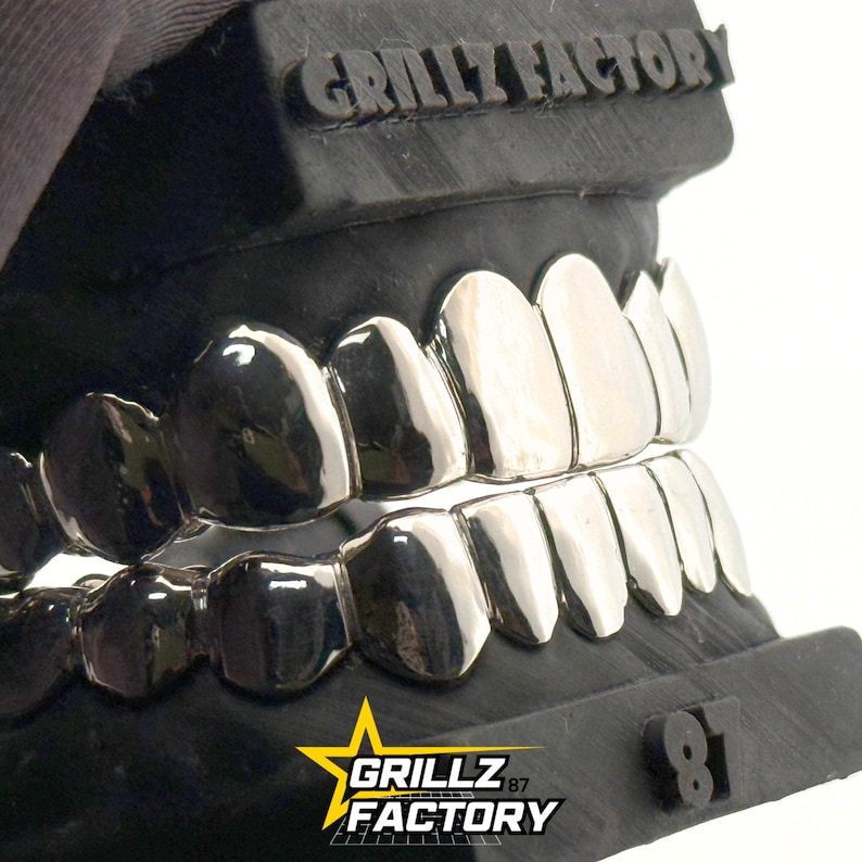 Custom fit silver grillz set featuring top and bottom dental cap
