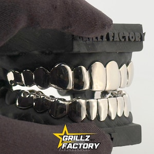 Front view of full set custom silver teeth caps on dental model.