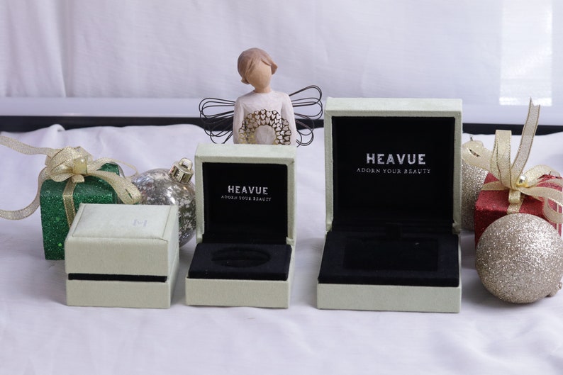 May include: Three white ring boxes with black velvet interiors. The boxes are labeled "Heavue Adorn Your Beauty".