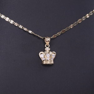 May include: A gold chain necklace with a small crown pendant featuring clear cubic zirconia stones.