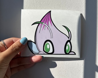May include: A purple and green cartoon character peeking over a white surface. The character has large green eyes and a pink flower on its head.
