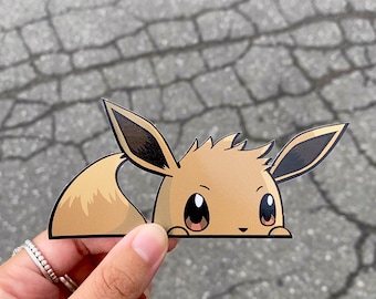 May include: A brown and tan cartoon Eeveelution peeking out from behind a surface. The Eeveelution has large brown eyes and a fluffy tail.