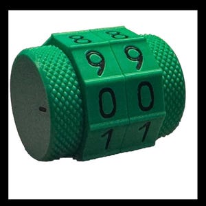 May include: A green plastic counter with three rotating dials. The dials display the numbers 990, 001, and 111.