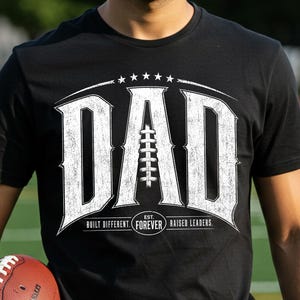 Vintage football dad PNG design with distressed varsity lettering and football