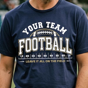 May include: Navy blue t-shirt with the text "YOUR TEAM FOOTBALL" and a football graphic. The shirt includes a yard line graphic and the phrase "LEAVE IT ALL ON THE FIELD".