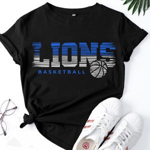 May include: Black t-shirt with a blue and white graphic that says "Lions Basketball" with a basketball graphic.