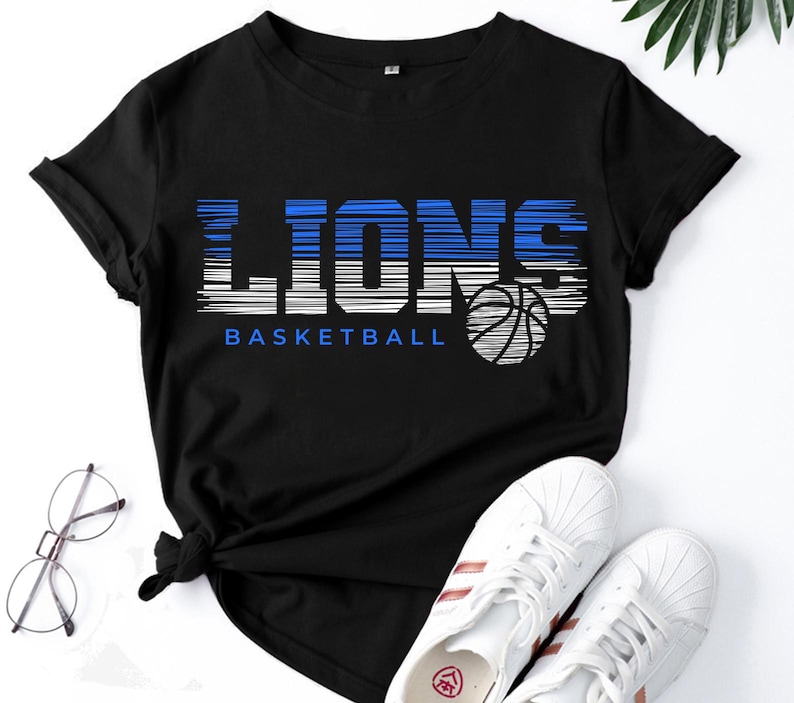 May include: Black t-shirt with a blue and white graphic that says "Lions Basketball" with a basketball graphic.