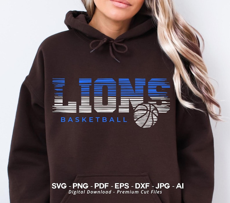 May include: A brown hoodie with a graphic design of the word "LIONS" in blue and white stripes with a basketball underneath. The text "BASKETBALL" is below the graphic.