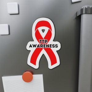 May include: Red awareness ribbon magnet with the text "TTP AWARENESS" on a silver refrigerator.