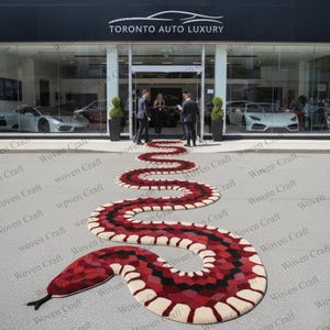 Peut inclure: Un tapis en forme de serpent, orné de motifs répétitifs, aux couleurs rouge, noir et crème, devant une concession automobile de luxe. Le texte 'TORONTO AUTO LUXURY' est visible sur l'enseigne du magasin.