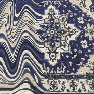 May include: A detailed close-up of a rug with a unique design. The rug features a blend of blue, beige, and white colors. The left side has a wavy pattern, while the right side showcases a traditional floral motif. The rug's border has a repeating floral design.