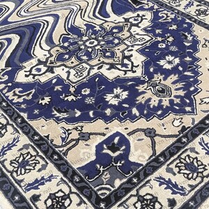 May include: A detailed close-up of a rug with a complex floral design. The rug features a navy blue central pattern with beige and gray accents. The border is a darker navy blue with floral motifs. The overall style is traditional.