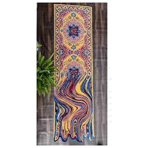 May include: A yellow, blue, red, and pink patterned rug with a geometric design. The rug has a fringed edge and is laid out on a wooden floor.