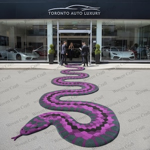 Puede incluir: Una gran alfombra exterior con forma de serpiente en tonos morado, negro y verde, que conduce a la entrada de un concesionario de coches de lujo. El diseño de la alfombra presenta un patrón geométrico. El letrero del concesionario dice "TORONTO AUTO LUXURY."