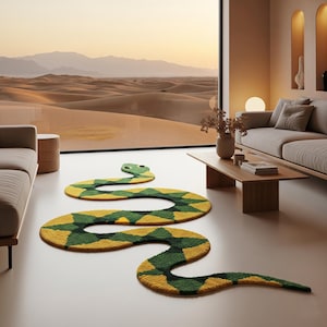 Puede incluir: Una alfombra decorativa con forma de serpiente en un salón. La alfombra presenta un patrón de rombos amarillos y verdes, con una cabeza verde. La habitación incluye una gran ventana con vistas al desierto, un sofá beige y una mesa de centro de madera. La alfombra mide unos 300 cm de largo.