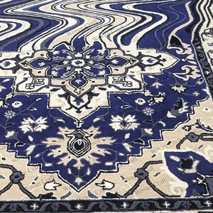 May include: A detailed close-up of a blue, beige, and cream-colored rug. The rug features a central medallion design with floral and geometric patterns. The border has a dark blue and cream design. The rug has a woven texture.