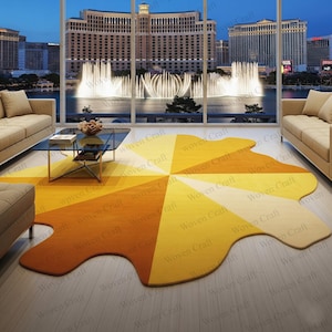Peut inclure: Un tapis abstrait coloré de forme unique. Le tapis présente un motif en forme d'éventail avec des nuances de jaune et d'orange. Il est placé dans un salon moderne avec vue sur un paysage urbain.