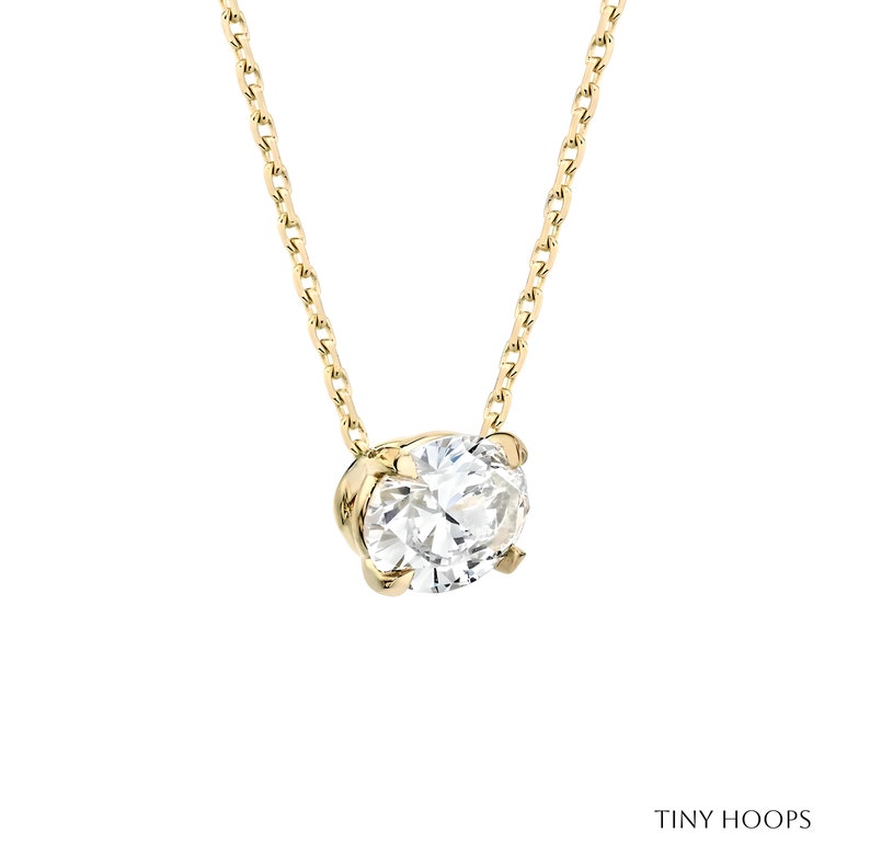 May include: A delicate gold chain necklace with a single round diamond pendant.