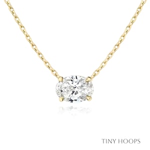 May include: A gold chain necklace with a large oval-shaped diamond pendant.
