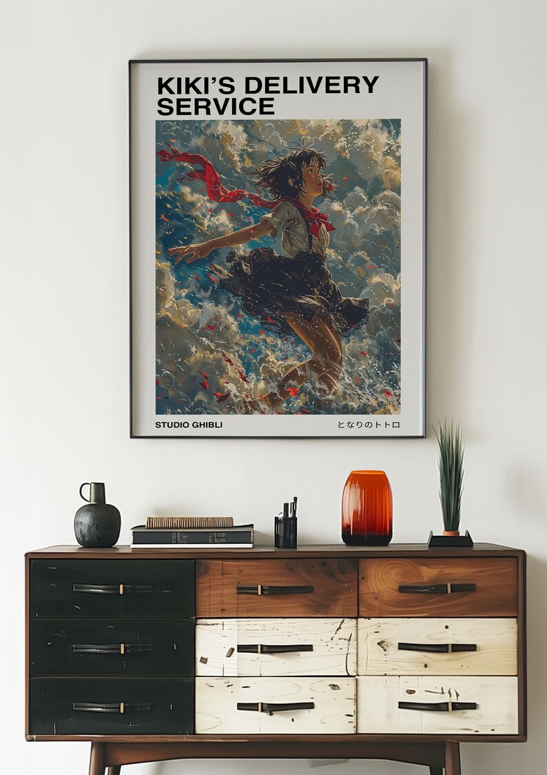 May include: A poster for the Studio Ghibli film Kiki's Delivery Service. The poster features a young woman with red hair flying through the air with a red scarf trailing behind her. The text on the poster reads "Kiki's Delivery Service" and "Studio Ghibli".