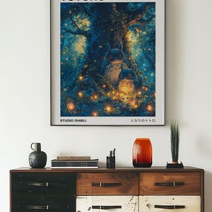 May include: A poster featuring the characters Totoro and a smaller Totoro from the Studio Ghibli film "My Neighbor Totoro". The poster has a blue and green background with glowing fireflies and a large tree. The text on the poster reads "My Neighbor Totoro" and "Studio Ghibli".
