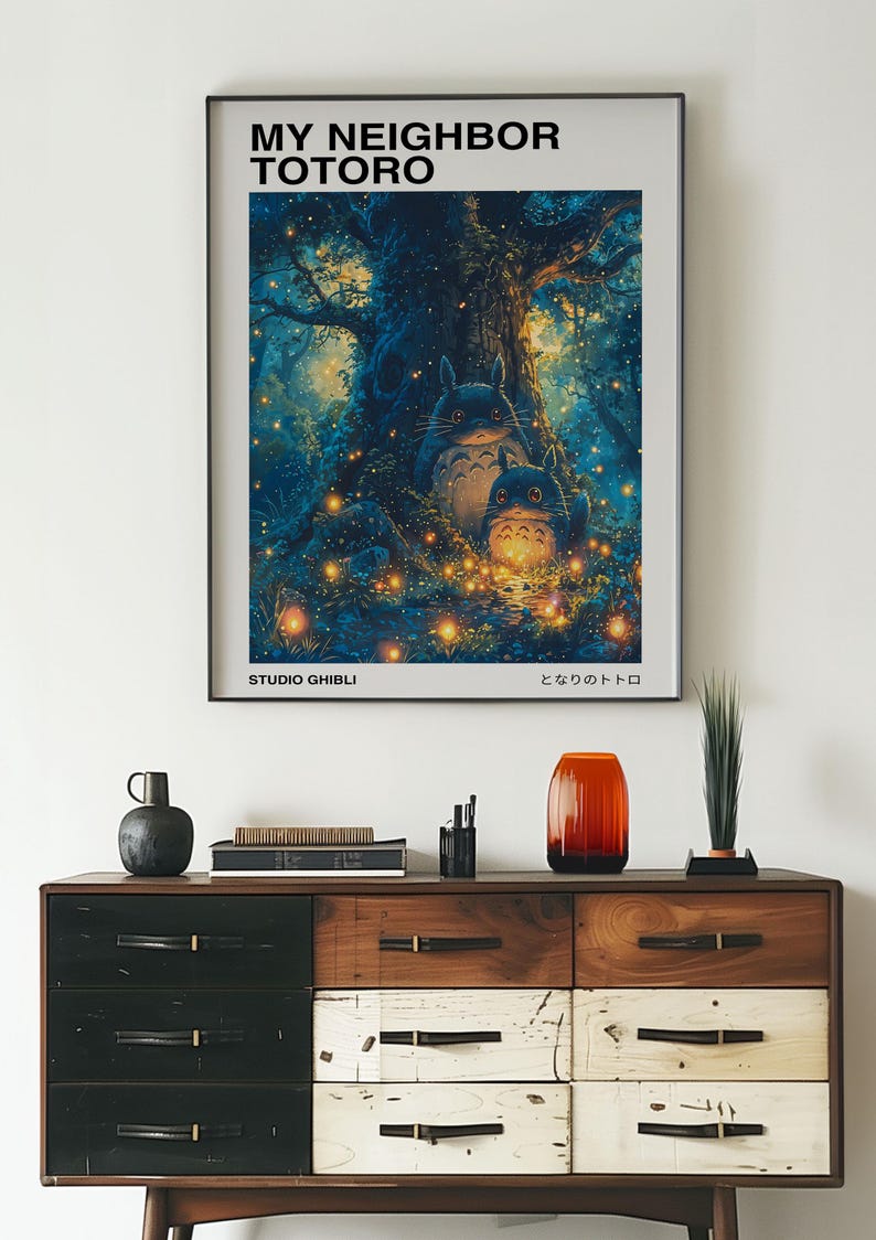 May include: A poster featuring the characters Totoro and a smaller Totoro from the Studio Ghibli film "My Neighbor Totoro". The poster has a blue and green background with glowing fireflies and a large tree. The text on the poster reads "My Neighbor Totoro" and "Studio Ghibli".