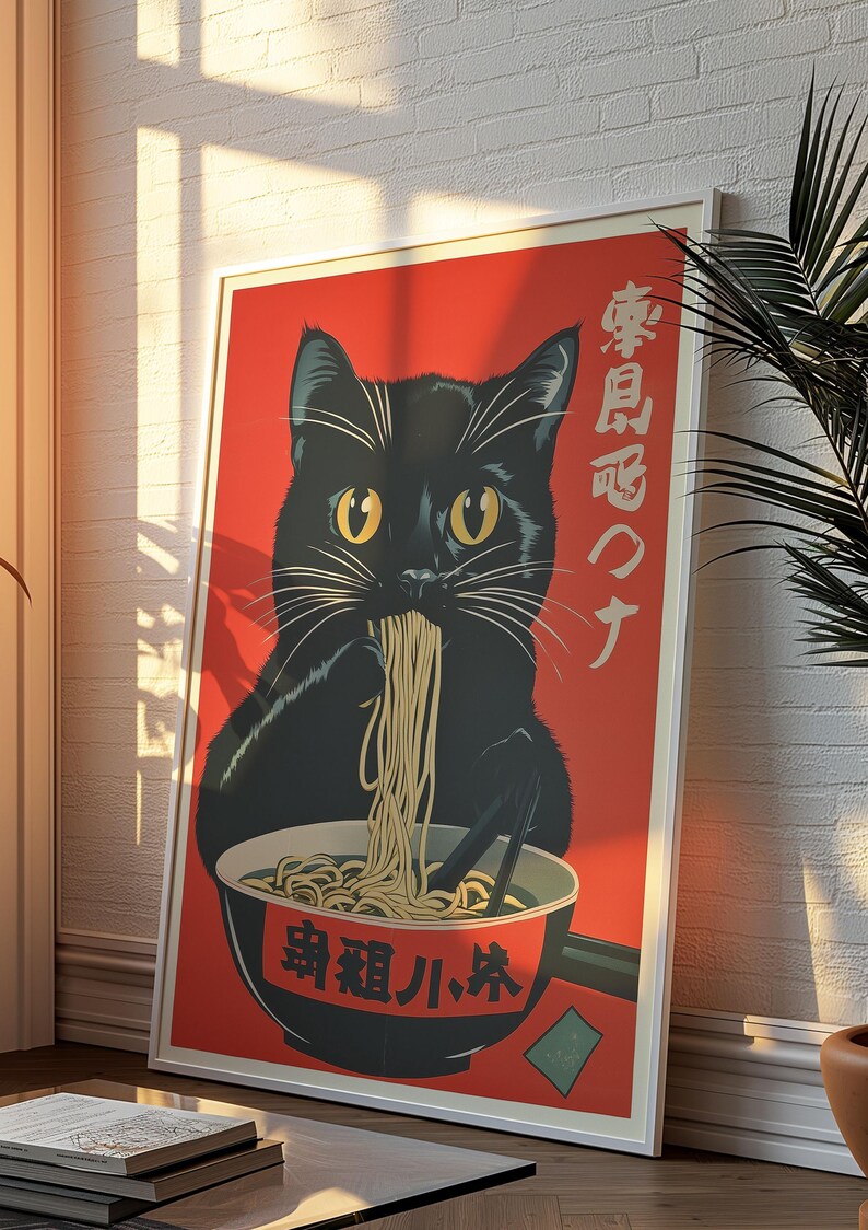 May include: A framed poster featuring a black cat eating ramen from a bowl. The cat is set against a red background with Japanese text. The poster has a white border and is leaning against a white brick wall.