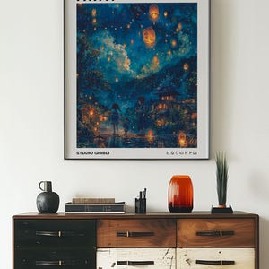 May include: A framed poster with a blue and purple night sky filled with glowing lanterns. The poster features the title "Spirited Away" and the text "Studio Ghibli" and "となりのトトロ".
