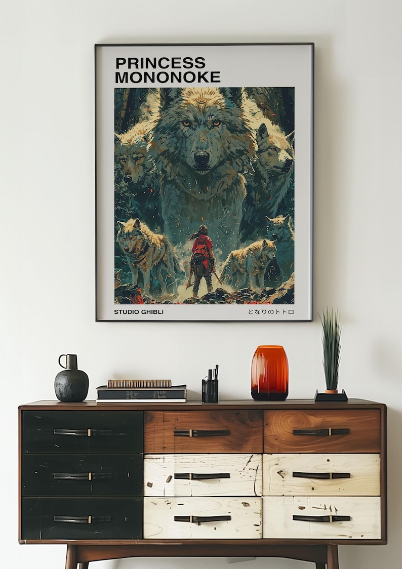 May include: A vintage-style poster for the Studio Ghibli film "Princess Mononoke" featuring a wolf and a young woman in a red outfit. The poster has the Japanese title "もののけ姫" and the text "Studio Ghibli" at the bottom.