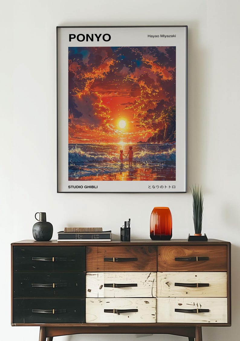 May include: A framed poster of the Studio Ghibli film "Ponyo" by Hayao Miyazaki. The poster features a sunset scene with two children walking on a beach. The text "Ponyo", "Studio Ghibli", and "となりのトトロ" (Totoro) are visible on the poster.