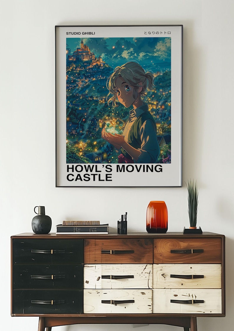 May include: A framed poster featuring a scene from "Howl's Moving Castle." The artwork depicts a young woman holding a glowing object, with a castle and cityscape in the background. The poster is displayed above a wooden dresser.