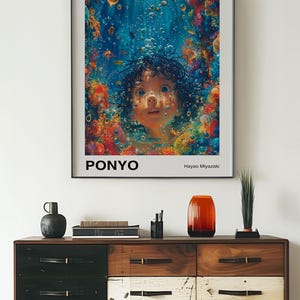 May include: A framed movie poster for the animated film "Ponyo" by Studio Ghibli. The poster features a young girl with dark hair and blue eyes, surrounded by colourful coral and bubbles. The title "Ponyo" is written in bold white letters at the bottom of the poster, along with the director's name, Hayao Miyazaki.