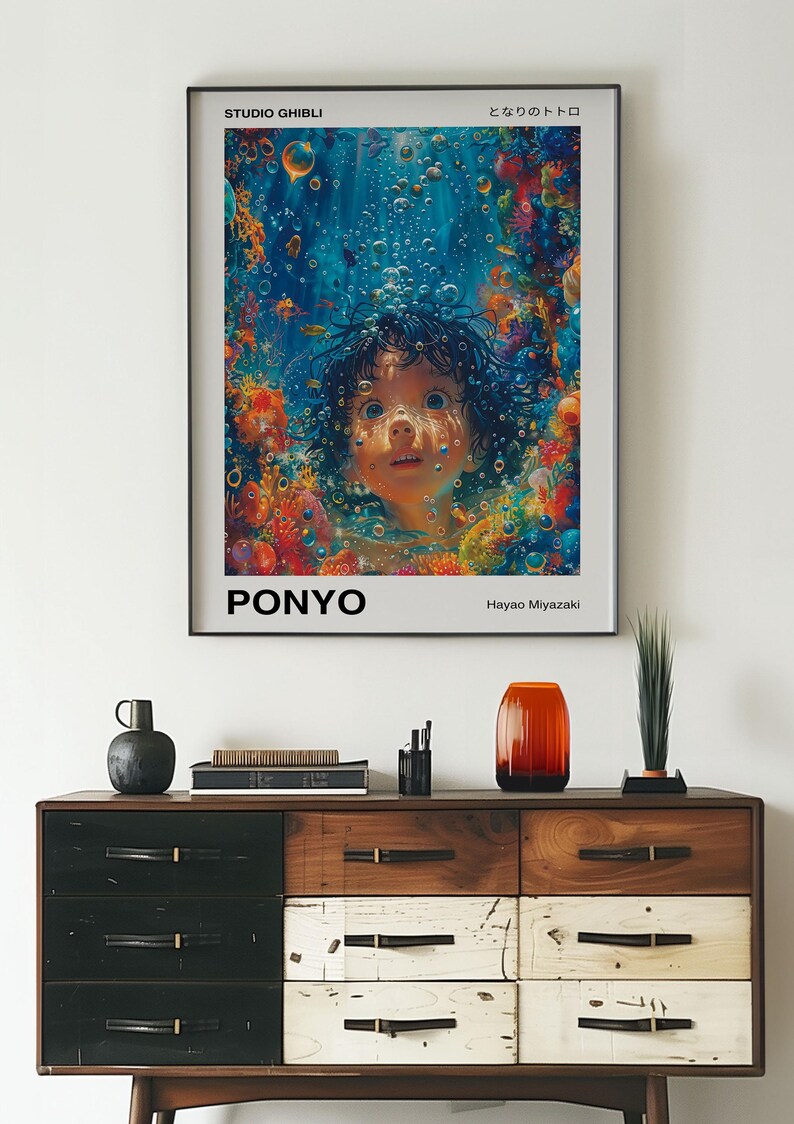 May include: A framed movie poster for the animated film "Ponyo" by Studio Ghibli. The poster features a young girl with dark hair and blue eyes, surrounded by colourful coral and bubbles. The title "Ponyo" is written in bold white letters at the bottom of the poster, along with the director's name, Hayao Miyazaki.