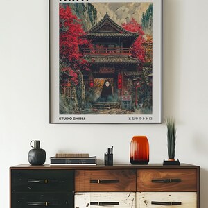 May include: A framed poster with a vintage aesthetic featuring a Japanese-style building with red accents and a character from the animated film Spirited Away. The poster includes the title "Spirited Away", the text "Studio Ghibli", and the Japanese text "となりのトトロ".