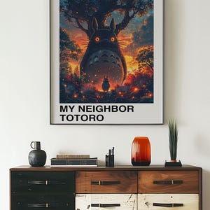 May include: A poster featuring a large, furry, grey creature with glowing eyes, standing in a forest at sunset. The creature is surrounded by fireflies. The poster is titled "My Neighbor Totoro" and includes the text "Studio Ghibli" and "となりのトトロ".