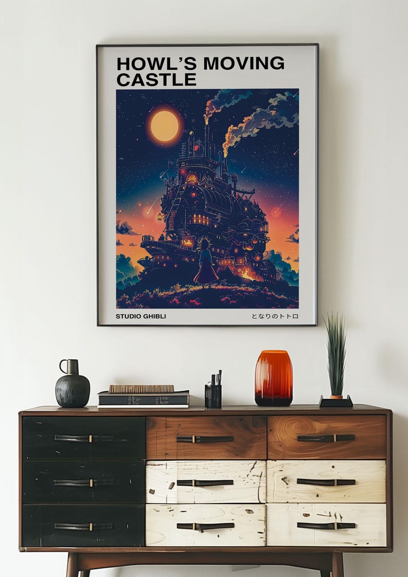 May include: A framed poster featuring the animated film "Howl's Moving Castle." The artwork depicts the castle against a night sky with a large moon. The poster includes the text "HOWL'S MOVING CASTLE" and "STUDIO GHIBLI."