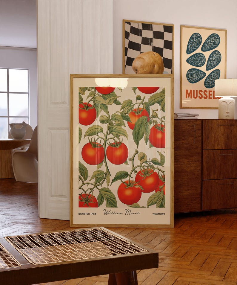 Pu&ograve; includere: Una stampa incorniciata con un'illustrazione botanica di pomodori rossi maturi su viti, con foglie verdi su sfondo crema. La stampa &egrave; intitolata "William Morris" e "Tomatoes". Altre opere d'arte incorniciate sono visibili sullo sfondo.
