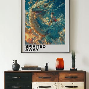 May include: A poster for the Studio Ghibli film Spirited Away, featuring a white dragon with a young girl riding on its back. The poster has the Japanese text "となりのトトロ" and the English text "Spirited Away" on it.