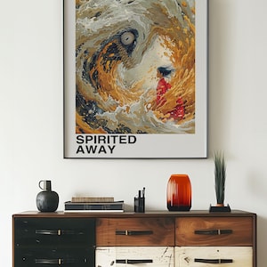 May include: A framed poster with a colorful illustration of a girl standing in front of a swirling wave. The poster is titled "Spirited Away" and features the text "Studio Ghibli" and "となりのトトロ" in Japanese.