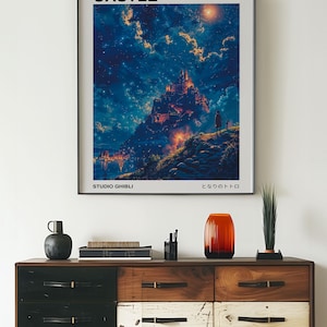 May include: A framed poster featuring the artwork from Howl's Moving Castle, with the text "HOWL'S MOVING CASTLE" at the top. The image depicts a castle on a hill under a starry sky. The words "STUDIO GHIBLI" are at the bottom.