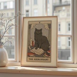 May include: Framed art print featuring a black cat as The Hierophant tarot card. The illustration includes an open book, candles, and a feather quill. The artwork is set against a cloudy, starry background with Roman columns.