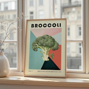 Könnte beinhalten: Gerahmter Kunstdruck mit einer grünen Brokkoli-Illustration vor einem geometrischen Hintergrund aus Rosa, Türkis und Schwarz. Das Wort "BROCCOLI" steht oben, mit "NO. 7" und "BAUHAUS EXHIBITION 1951" unten.
